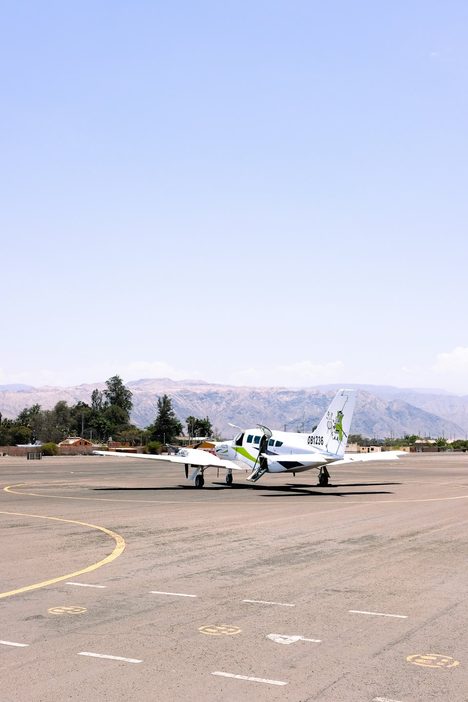 Un aereo bimotore è parcheggiato sulla pista con le scale estese.