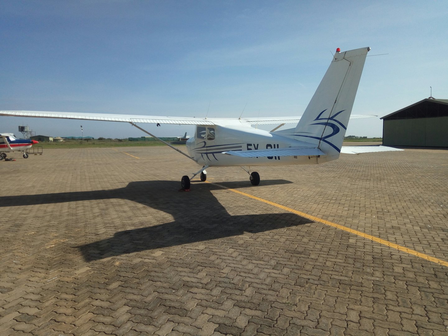 Aereo monomotore parcheggiato su un aerodromo asfaltato.